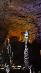 Tourist cave attraction documented with colored lights and boat rides