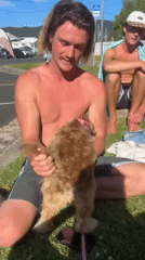 Beach group relaxes with dog in Bulli, Australia