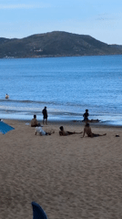 Sunny morning at Quy Nhon's beach, umbrellas out and people in the water