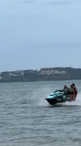 Four people jet skiing through choppy Ko Samui waters