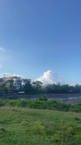Person fishes from black sand beach in Kediri