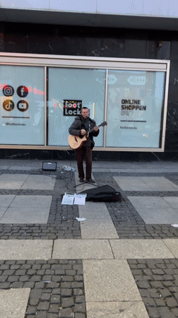 Street musician performs outside Foot Locker in Berlin
