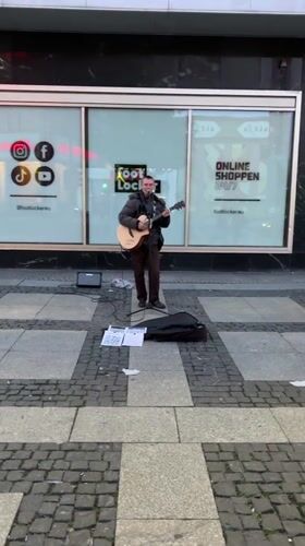 Street musician performs outside Foot Locker in Berlin