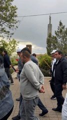 Group walks brick pathway near monument in Yerevan, Armenia