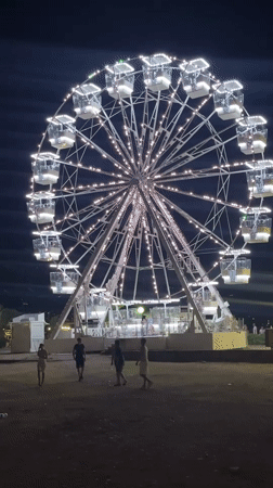 Budva's beachfront Ferris wheel lights up a summer night
