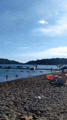Busy beach day with swimming and sunbathing activities