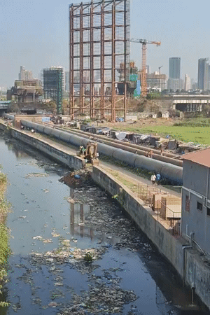 Mumbai residents navigate polluted urban landscape near industrial infrastructure