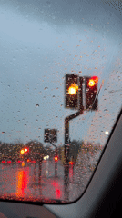 Vehicle waits at red lights during evening rain in Durham