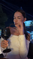 Three friends share drinks at outdoor table in Thailand