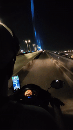 Nighttime motorcycle ride across bridge in Hong Gai Ward