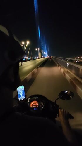Nighttime motorcycle ride across bridge in Hong Gai Ward