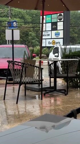 Rain shower hits outdoor cafe in Si Sunthon Thailand
