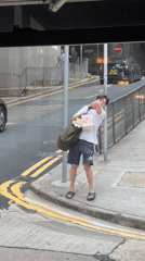 Man carries small dog in bag on Hong Kong street