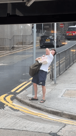 Man carries small dog in bag on Hong Kong street
