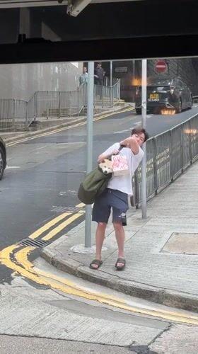 Man carries small dog in bag on Hong Kong street
