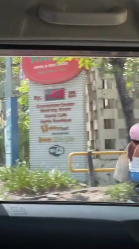 Two people spotted on scooter in Kuta street scene
