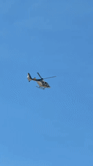 Police helicopter flies over Valencia streets on sunny morning