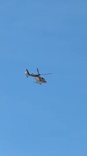 Police helicopter flies over Valencia streets on sunny morning