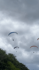 Colorful paragliders spotted over Kuta Selatan on overcast morning