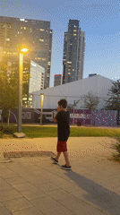 Boy gestures on Tel Aviv street amid urban backdrop