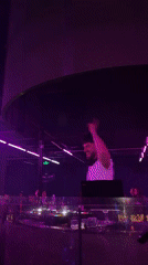 DJ performs at illuminated nightclub booth in Sofia