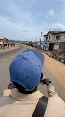 Motorcyclist travels paved road in Aketu-Oja, Nigeria
