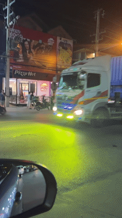 Container truck observed passing vehicles at night in Thailand