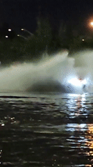 Water erupts from manholes in front of a car in Saint Petersburg
