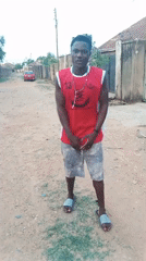 Young man gestures on dirt street in Jos