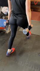 Woman performs dumbbell lunges at Saint Petersburg gym