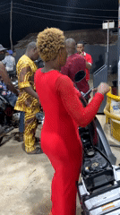 Woman in red dress rides motorcycle at Lokoja gas station