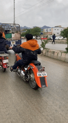 Motorcyclists navigate wet streets in Quetta, Pakistan