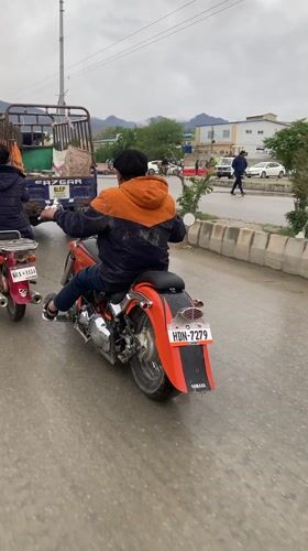 Motorcyclists navigate wet streets in Quetta, Pakistan