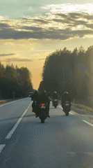 Motorcycle group rides in formation through Virši, Latvia
