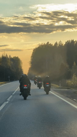 Motorcycle group rides in formation through Virši, Latvia