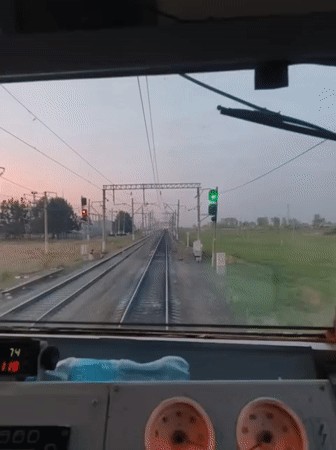 Train cabin POV footage shows forward movement past trackside signals