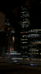 Moscow skyscrapers illuminated at night captured from moving vehicle
