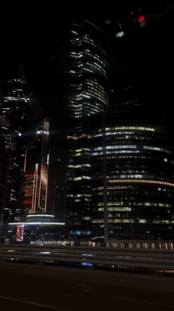 Moscow skyscrapers illuminated at night captured from moving vehicle