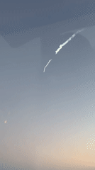 Rocket lifts off from Vandenberg, smoke trail arcing across the sky