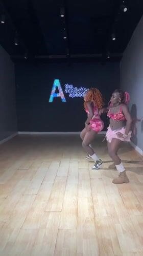 Two women dance in pink outfits at Lekki studio