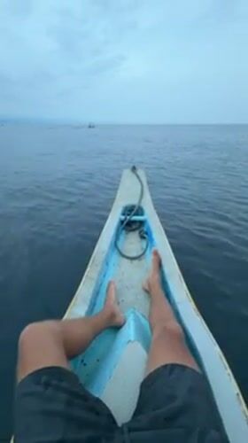Person resting in wooden boat observed in Buleleng, Indonesia