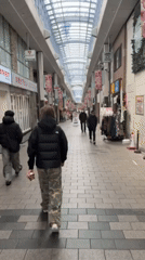 Person walks through covered shopping arcade in Suginami City