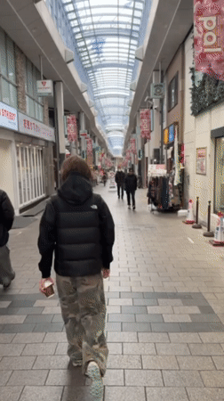 Person walks through covered shopping arcade in Suginami City