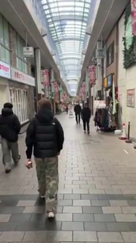 Person walks through covered shopping arcade in Suginami City