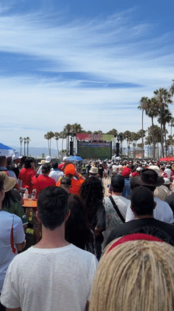 LA crowd watches soccer on big outdoor screen near beach