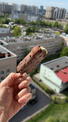 Woman enjoys ice cream bar against city backdrop
