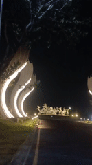 Illuminated horse sculpture at a Surabaya roundabout, captured at night