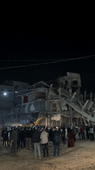 Crowd watches nighttime excavation at collapsed Gaza building