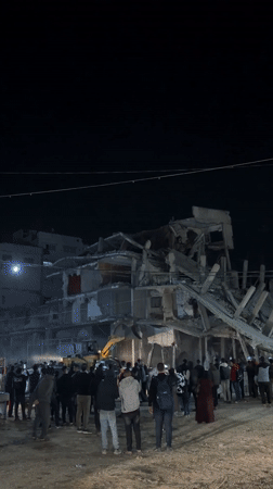 Crowd watches nighttime excavation at collapsed Gaza building