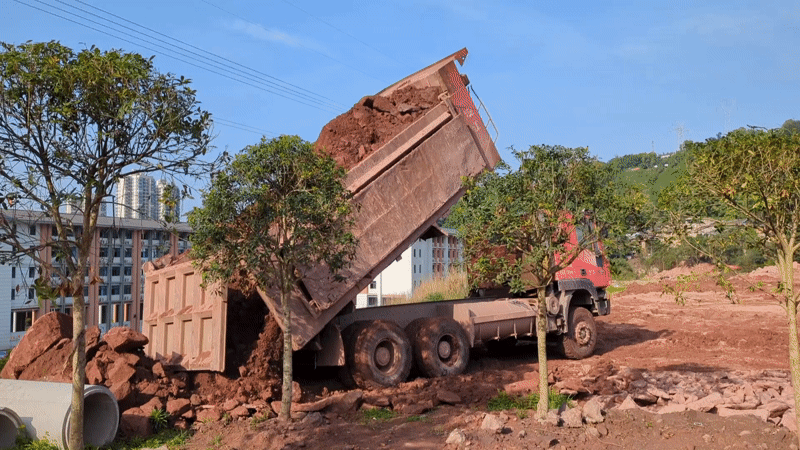 Dump truck deposits red dirt in Jiangjin, China
